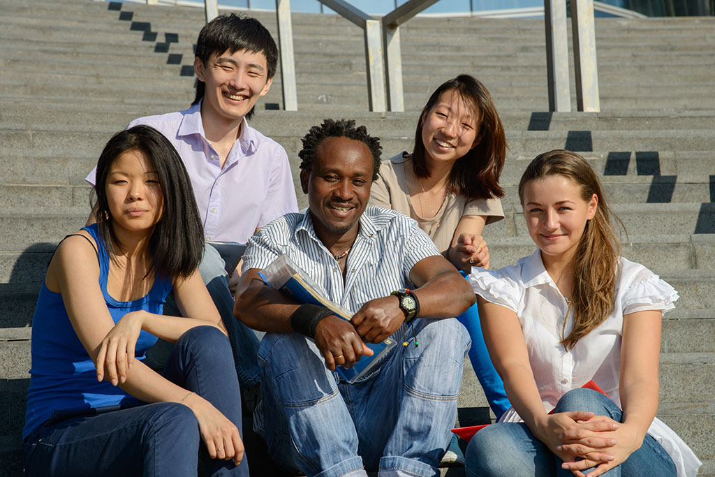 Multiethnic group of university students sitting on steps
