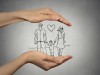 woman's hands protecting happy family